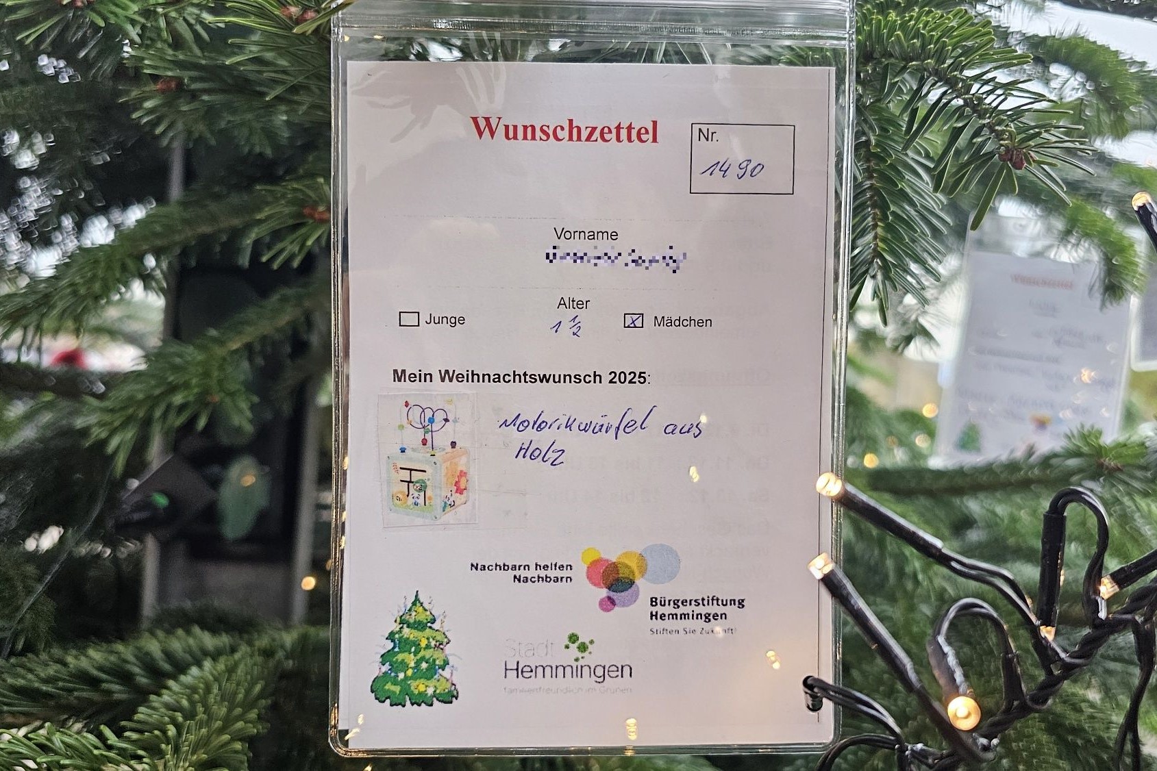 An drei Weihnachts- bäumen hängen Kinderwünsche